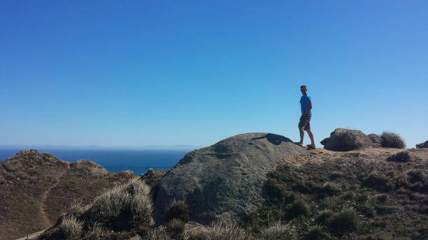 istock Man standing on rocky cliff in Point Reyes California 1503209669