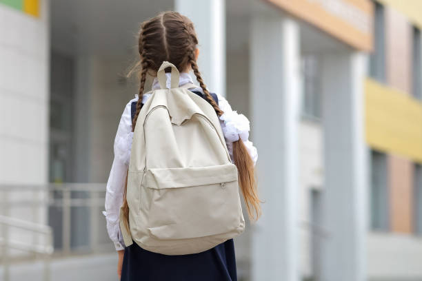 istock Long-haired schoolgirl with backpack goes to primary school 1503213162