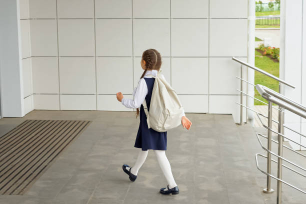 istock Brown-haired schoolgirl carrying backpack enters school 1503213171