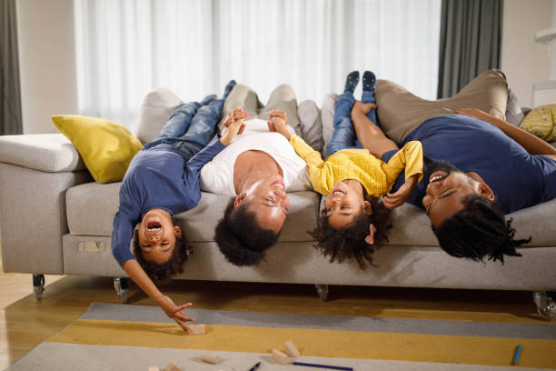 istock Playful black family lying upside down on sofa at home. 1503213192