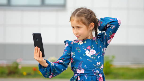 istock Brown-haired schoolgirl making selfies on black smartphone 1503213210