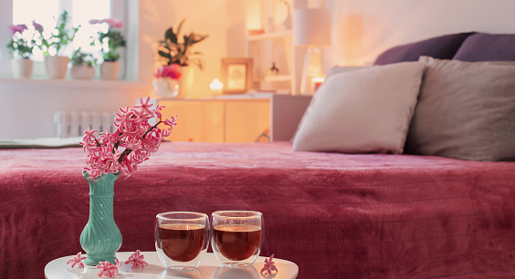 two thermo glasses  of coffee on white table in pink bedroom