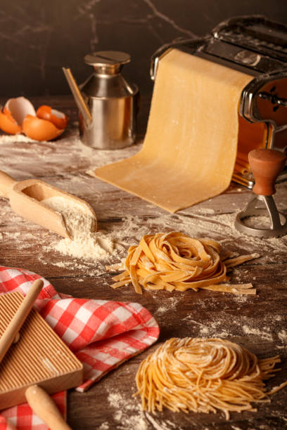istock Fresh pasta homemade preparation. Pasta machine and ingredients on a kitchen table. 1503214893