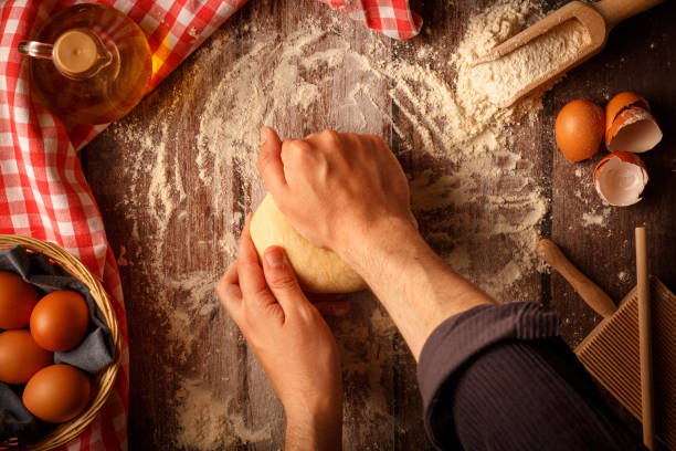 istock Baker knead pasta dough with hands on kitchen table background working with flour and eggs 1503215089