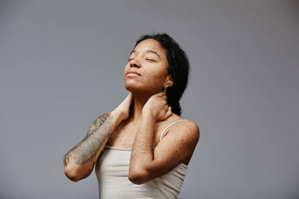 Black young woman with real skin texture posing confidently Minimal portrait of black young woman with real skin texture posing confidently with eyes closed, copy space black tattoo stock pictures, royalty-free photos & images