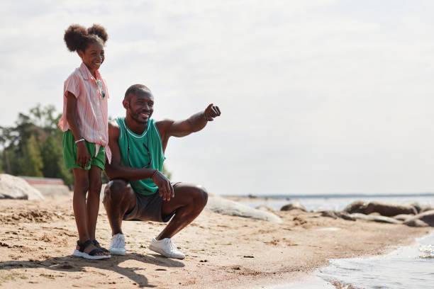 istock Dad and daughter walking on the beach 1503225251