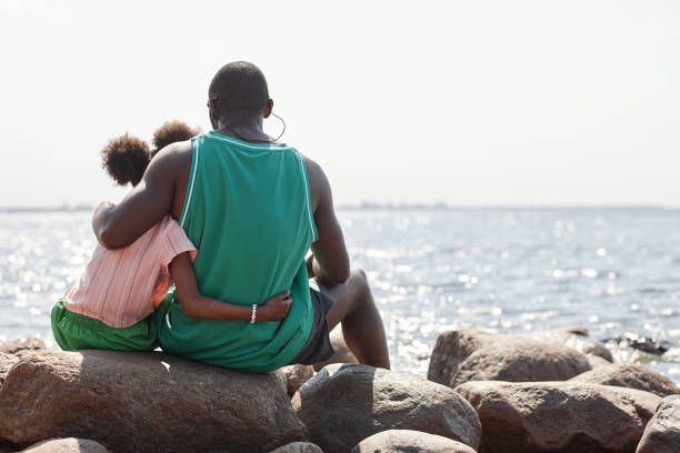 istock Dad sitting on the beach with his daughter 1503225260