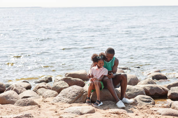 istock Dad using smartphone with his daughter outdoors 1503225265