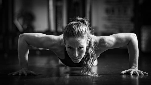 Woman Doing Push-ups in the gym. Strength Training.