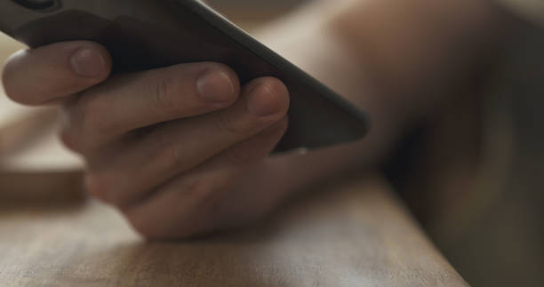 istock young man hands using smartphone sitting at the table closeup 1503228938
