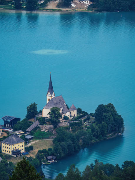 Aerial view of the church of Maria Worth (Maria Wörth) at Worthersee (Wörthersee) Aerial view of the church of Maria Worth (Maria Wörth) at Worthersee (Wörthersee) in the summer as seen from the Pyramidenkogel lookout tower maria woerth stock pictures, royalty-free photos & images