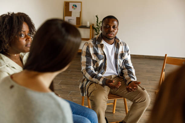 istock Young man talking about his mental health with a group during a group therapy session 1503234443