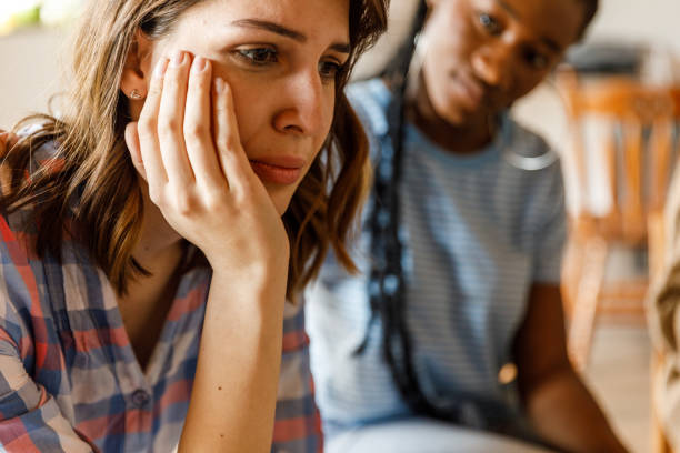 istock Sad young woman sitting with head in hand during a group therapy session 1503234618