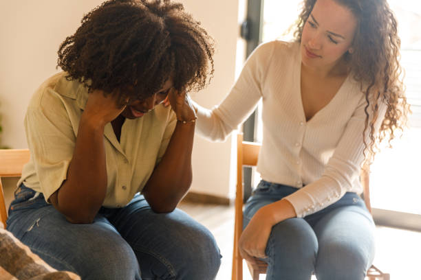 istock Young woman sitting with head in hands during a group therapy session 1503234699