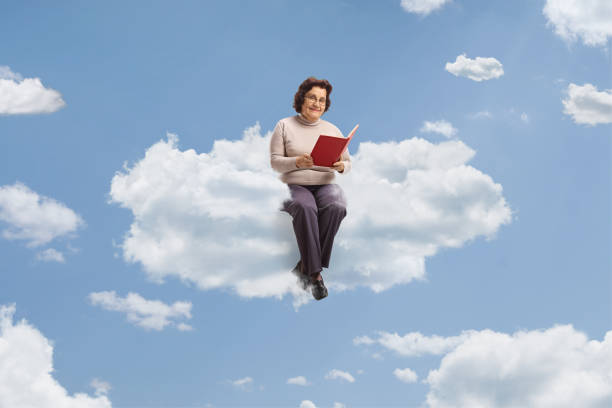 istock Elderly woman with a book sitting on a cloud 1503237372
