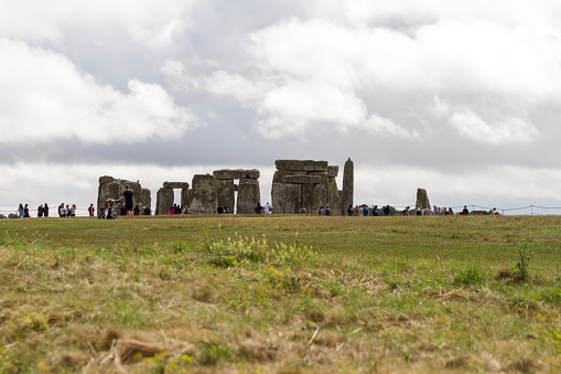 View of Stonehenge with green meadow and blue sky on a sunny day in Spring, United Kingdom