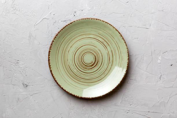 istock Top view of empty green plate on cement background. Empty space for your design 1503242478