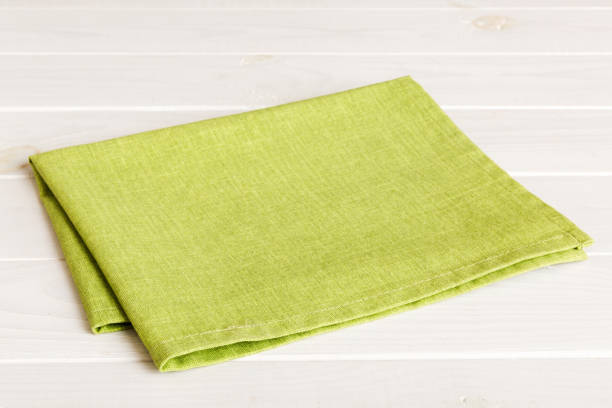 istock top view with green kitchen napkin isolated on table background. Folded cloth for mockup with copy space, Flat lay. Minimal style 1503242520