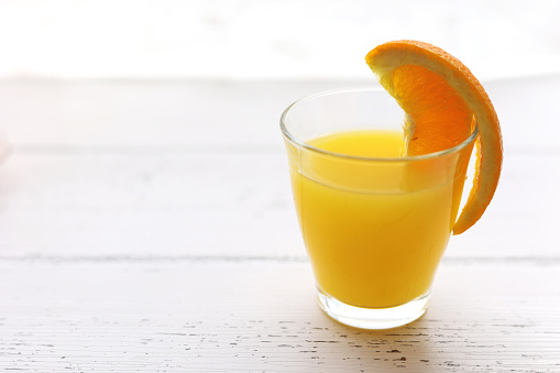 Woman's hands pouring freshly squeezed orange juice