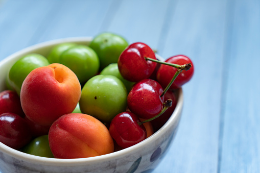 Bowl of healthy fresh fruit on wooden background