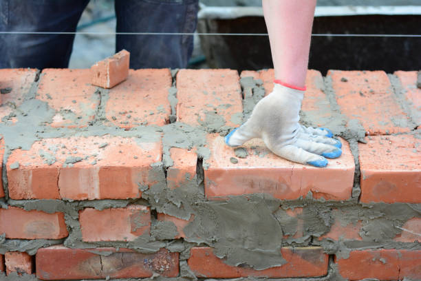 ein maurer baut eine gemauerte hauswand. nahaufnahme auf halber fledermaus- und viertelziegelstein auf hausziegelwandkonstruktion. - mason brick bricklayer installing stock-fotos und bilder