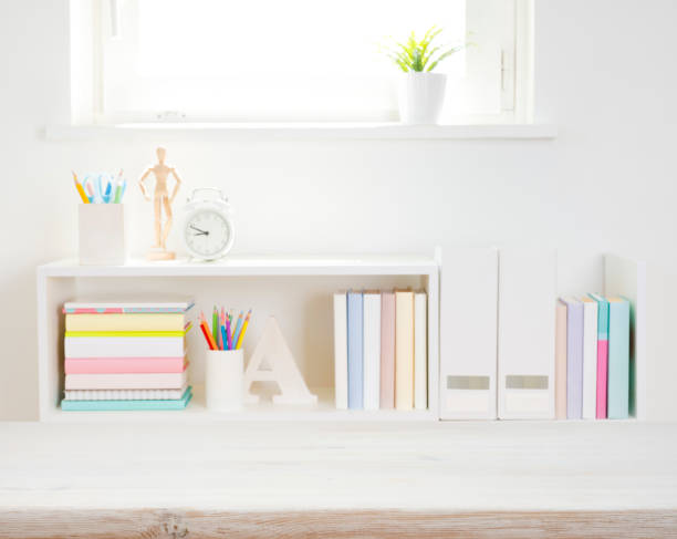 istock Wooden desk top on blurred bookshelf with school supplies background 1503259727