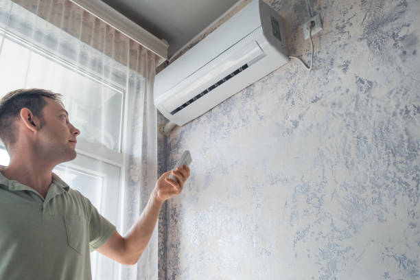 istock Young man switching on air conditioner at home for comfort temperature with remote controller in hot summer 1503259909