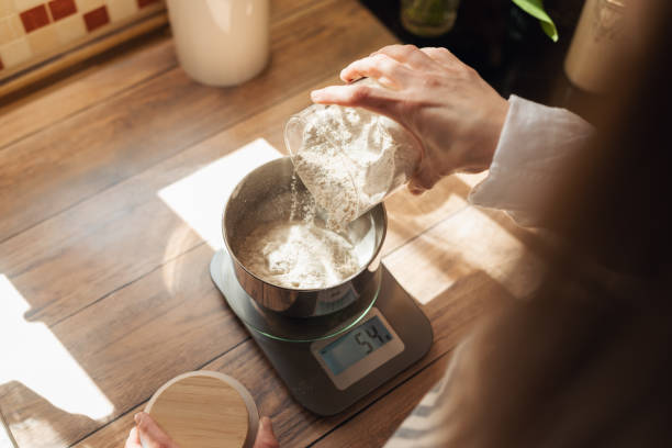 Measuring flour with electronic kitchen scales for cooking something stock photo