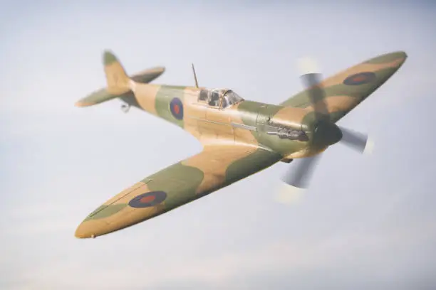 A classic Mk 1 Spitfire flies over the British countryside. Scale model photography.