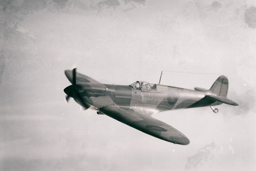 A classic Mk 1 Spitfire flies over the British countryside. Scale model photography.