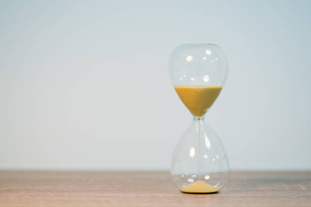 istock Sandglass standing on the table on light gray background, close up, copy space 1503262196