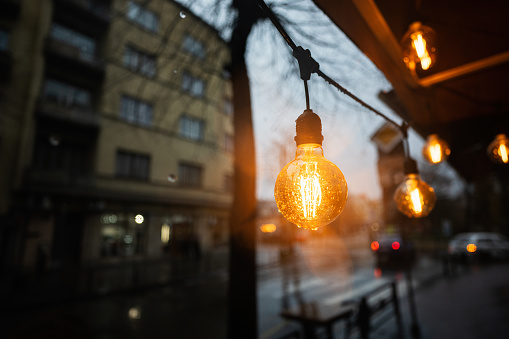 Light bulbs garland in rain city street.