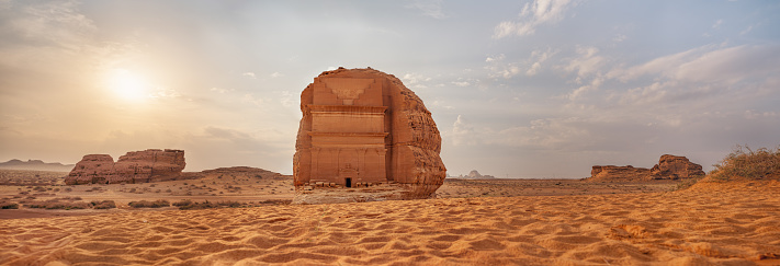 Tomb Lihyan Son of Kuza or Qasr al-Farid at Hegra, Saudia Arabia - most popular landmark in Mada'in Salih archaeological site, sandy desert landscape, morning sun background - high resolution panorama.