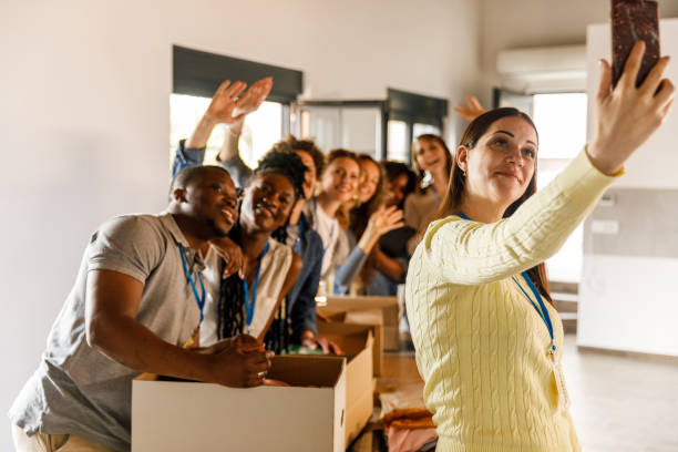 istock Group of diverse volunteers taking selfies together while preparing donations 1503277942