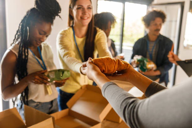 Group of volunteers preparing donation boxes with clothes stock photo