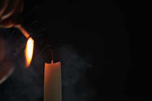 tall candle lighting in the dark environment, shallow focus