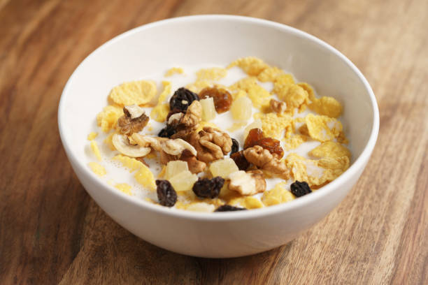 istock corn flakes with fruits and nuts in white bowl on wood table 1503287728