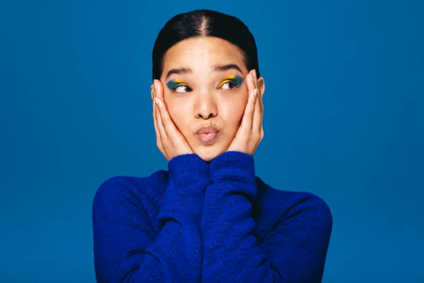 istock Young woman embracing her face while wearing makeup in a studio 1503288228