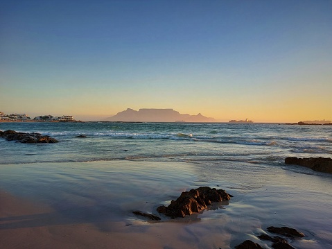 A beautiful view of Table Mountain from Bloubergstrand with the sun going down