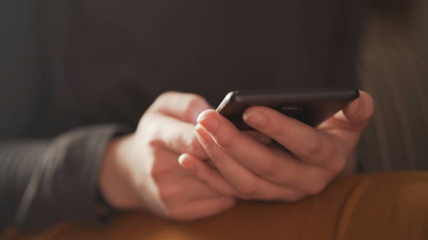istock teen girl using smartphone backlit by window light 1503290034