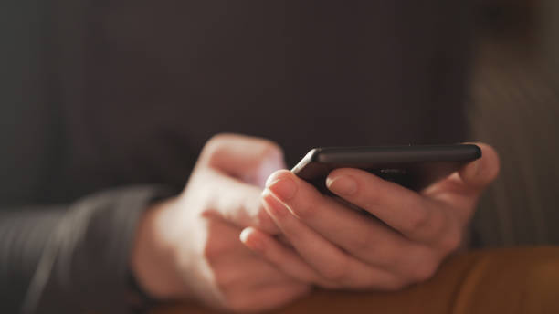 istock teen girl using smartphone backlit by window light 1503290136