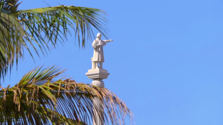 Statue of Columbus Standing Tall Amidst Verdant Forest Trees in 4k slow motion 60fps