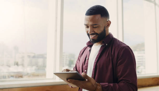 istock Happy, email and a man with a tablet at work for online business, communication and connection. Smile, digital and a male web designer with technology, reading on an app and working on the internet 1503295895
