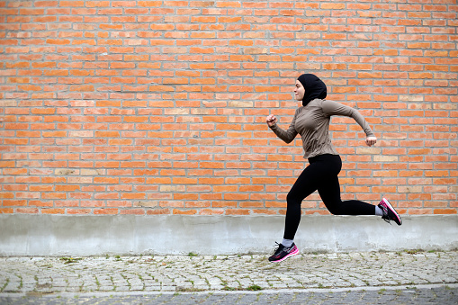 Middle-eastern female exercising in a city. About 25 years old, Arab woman.