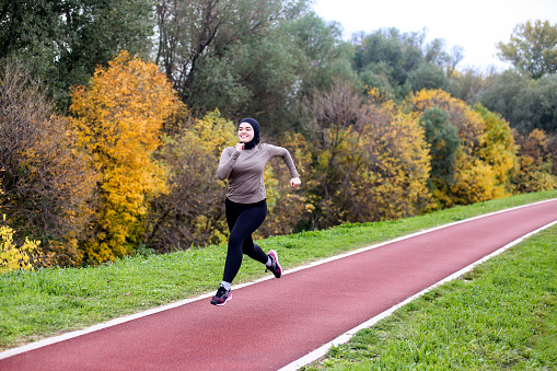 Middle-eastern female running on a track. About 25 years old, Arab woman.