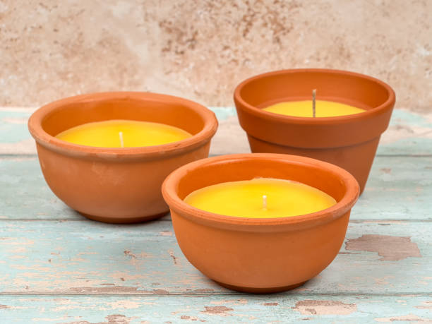 candele alla citronella in vasi di terracotta. un repellente per zanzare per uso esterno. - candle lemon grass insect repellant insect foto e immagini stock