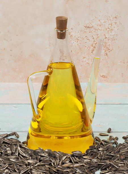 A jug of sunflower oil on blue wooden background stock photo