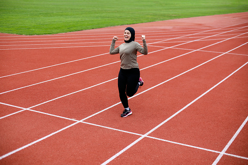 Middle-eastern female running on a track. About 25 years old, Arab woman.