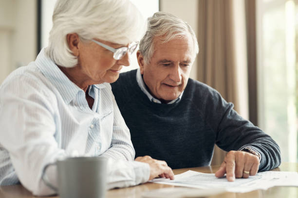 istock Retirement, life insurance documents and old couple with pension plan and policy with financial security. Savings, bills and budget, elderly woman and man at home with legal paperwork and planning 1503298099