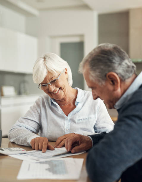 istock Retirement, life insurance documents and old couple with graphs and spreadsheet, pension plan and financial security. Savings, bills and budget, elderly woman and man at home with policy paperwork 1503298103
